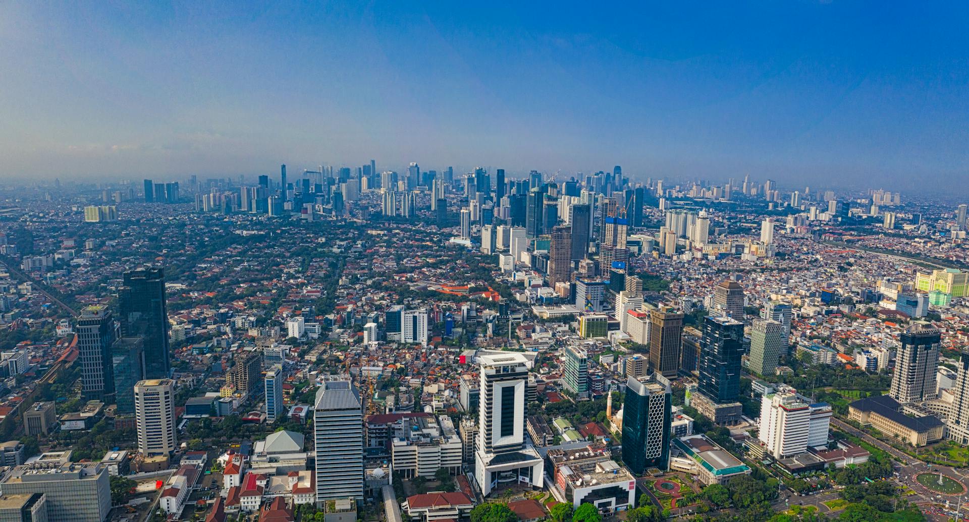 A high-angle shot showcasing the vibrant cityscape of Jakarta, Indonesia under clear skies.