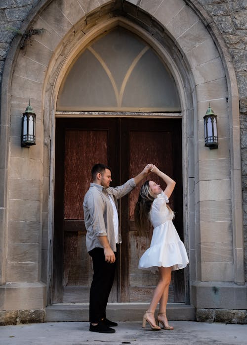 A couple dancing in front of a church