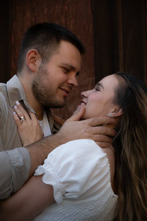 Free A couple embracing in front of a wooden door Stock Photo