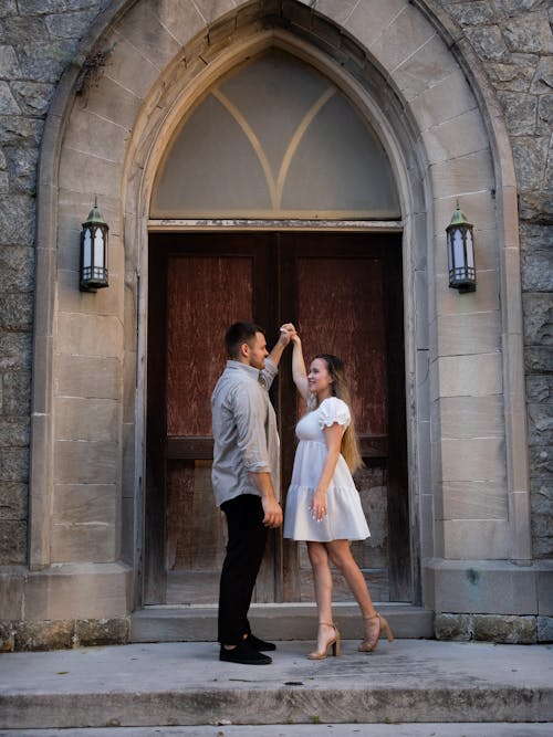 Free A couple standing in front of a church door Stock Photo