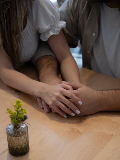 Free A man and woman holding hands at a table Stock Photo