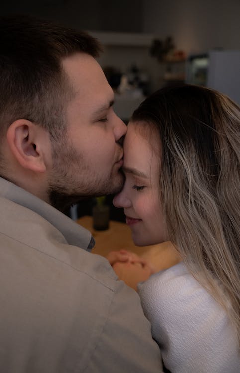 Free A man and woman are kissing in a kitchen Stock Photo