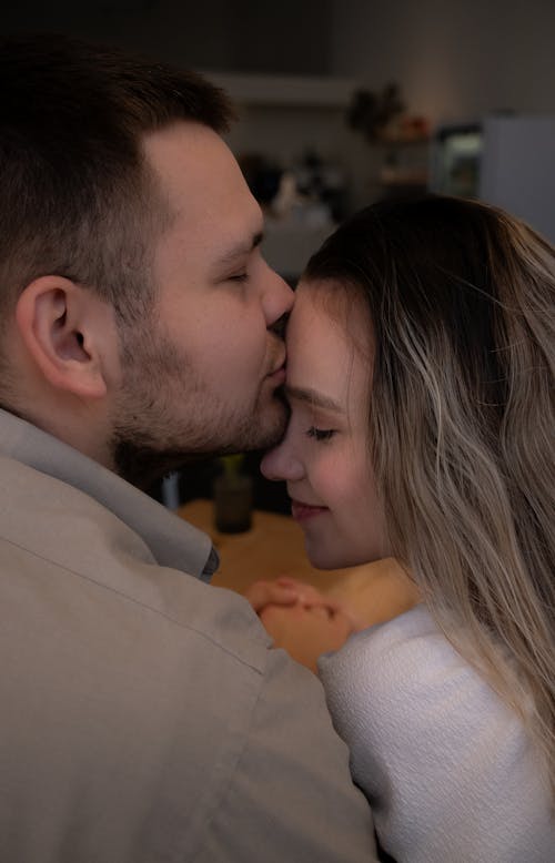 Free A man and woman are kissing in a kitchen Stock Photo