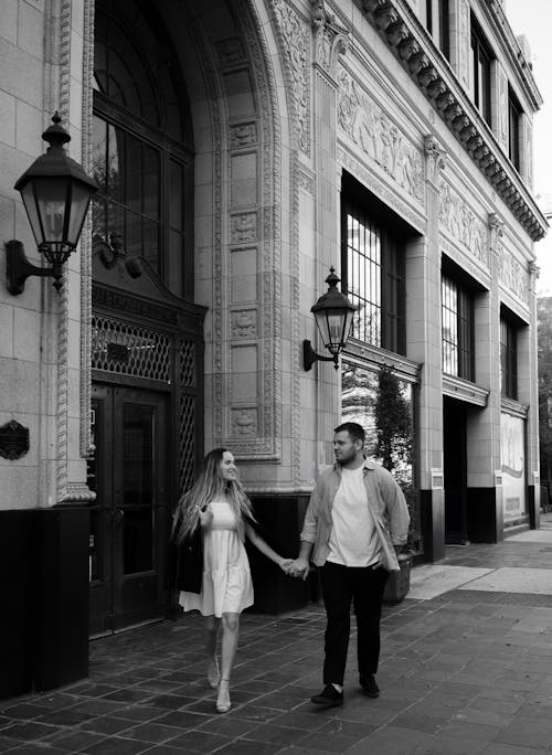 A couple holding hands walking down the street