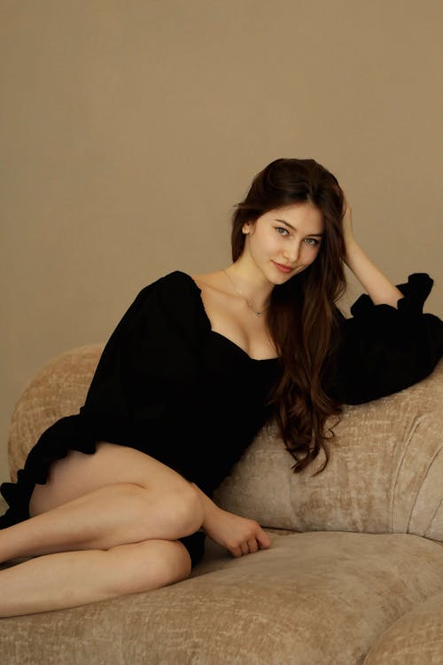 Free Brunette Woman Posing on Sofa  Stock Photo