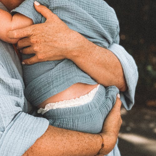 Free Freckled Hands of a Woman Holding a Baby Stock Photo