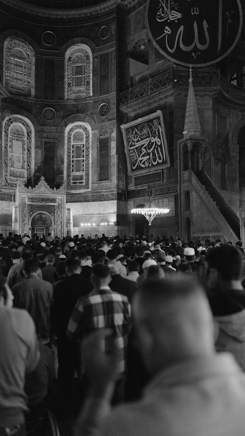 A black and white photo of people in a mosque