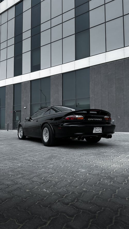 A black sports car parked in front of a building