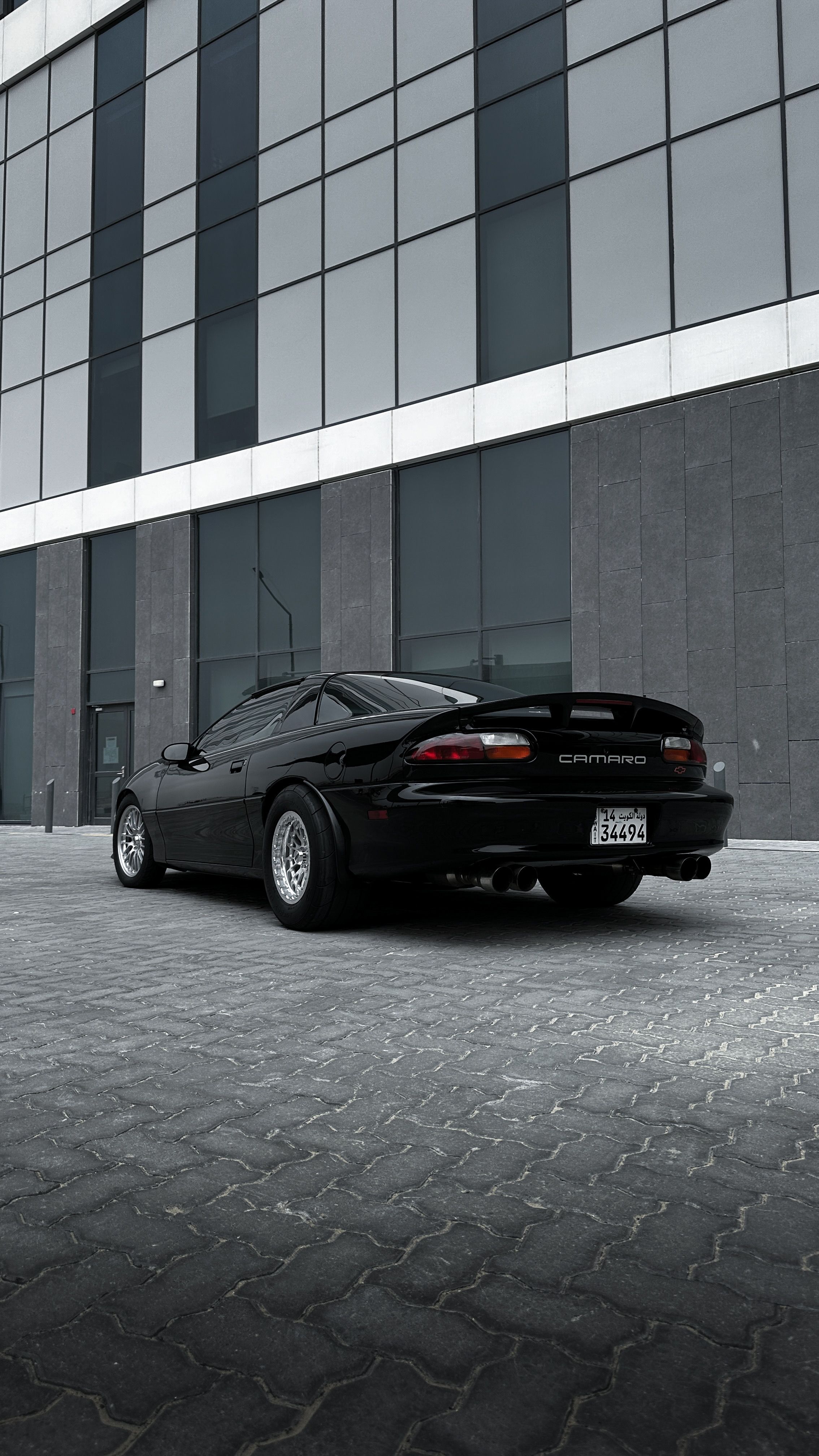 A black sports car parked in front of a building · Free Stock Photo
