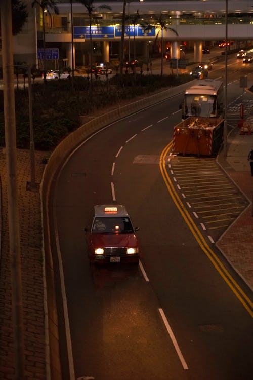 A taxi drives down a street at night