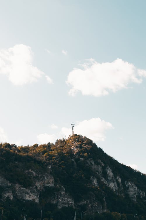 A cross on top of a mountain with clouds