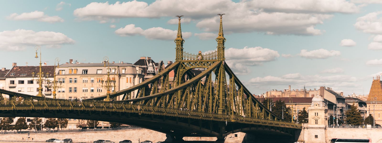 Sunlit Liberty Bridge in Budapest spans the Danube, showcasing urban architecture and cityscape.