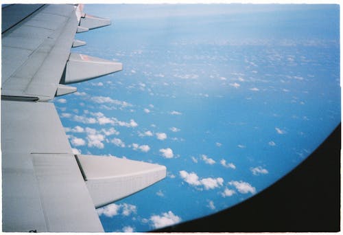 A view of the wing of an airplane flying over the ocean