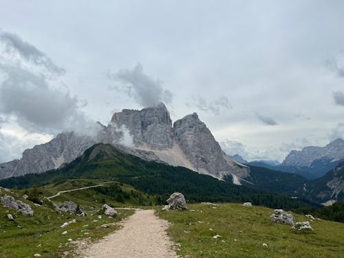 A dirt path leading to a mountain range