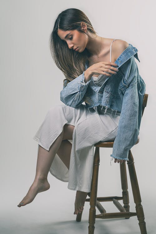 Free A woman sitting on a stool with her legs crossed Stock Photo