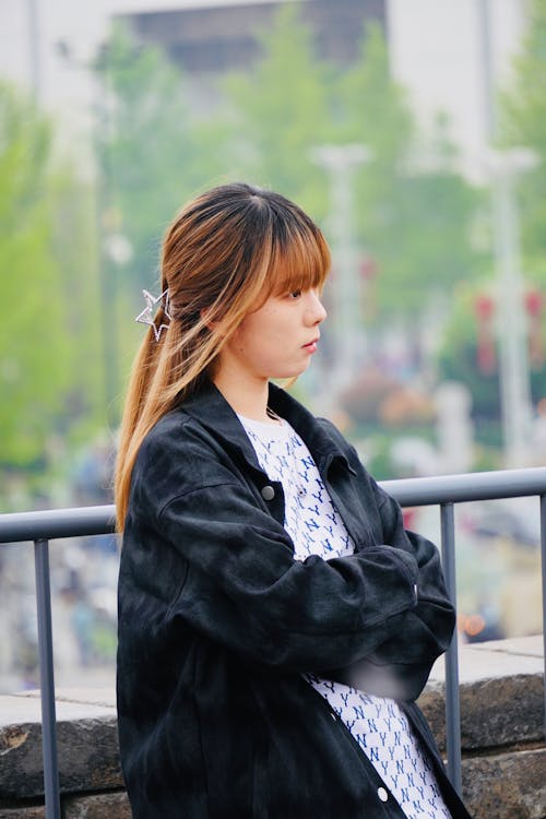 Free A woman with her arms crossed looking out over the city Stock Photo