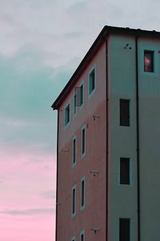 Tall building with a pastel sky background, showcasing urban architecture at dusk.