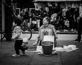 在伦敦，一名街头表演者在水桶上打鼓，吸引了人群的注意