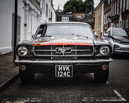 一辆停在伦敦街头的经典福特野马，其前视图展现了标志性的设计