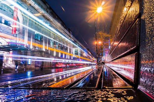 一张充满活力的长曝光照片，展现了英国曼彻斯特的城市灯光与潮湿街道