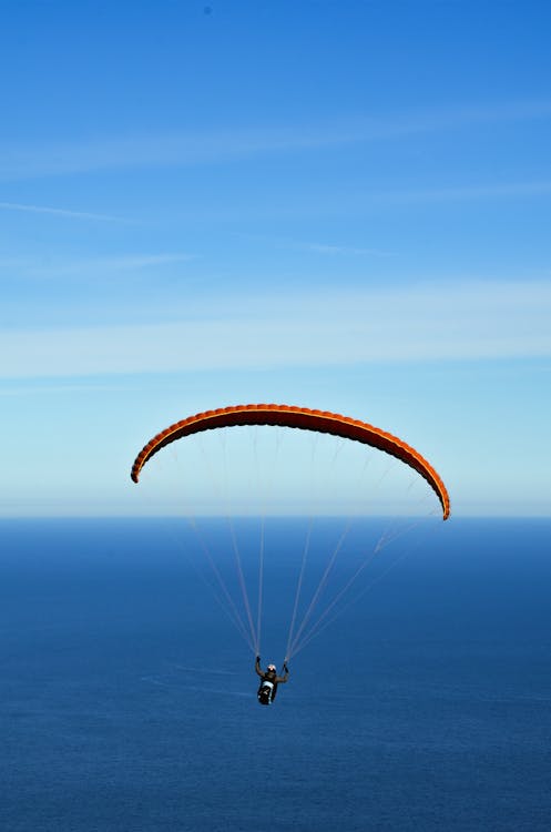 Man on Parachute over Blue Sea