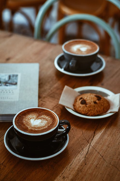 Free Black Teacup on Saucer Beside Cookie Stock Photo