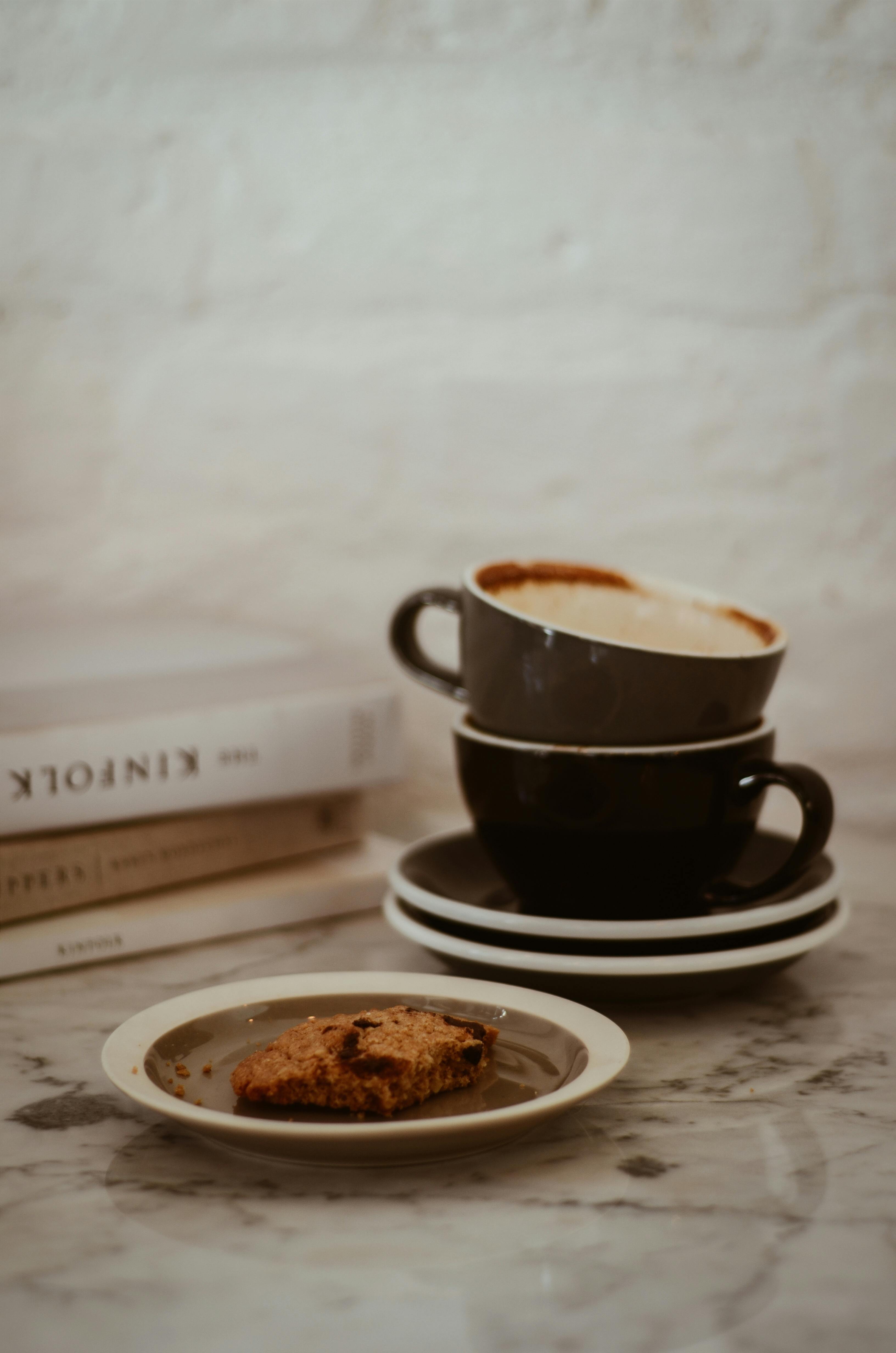 大理石桌子上堆放的咖啡杯和饼干，在室内营造出舒适的静物场景