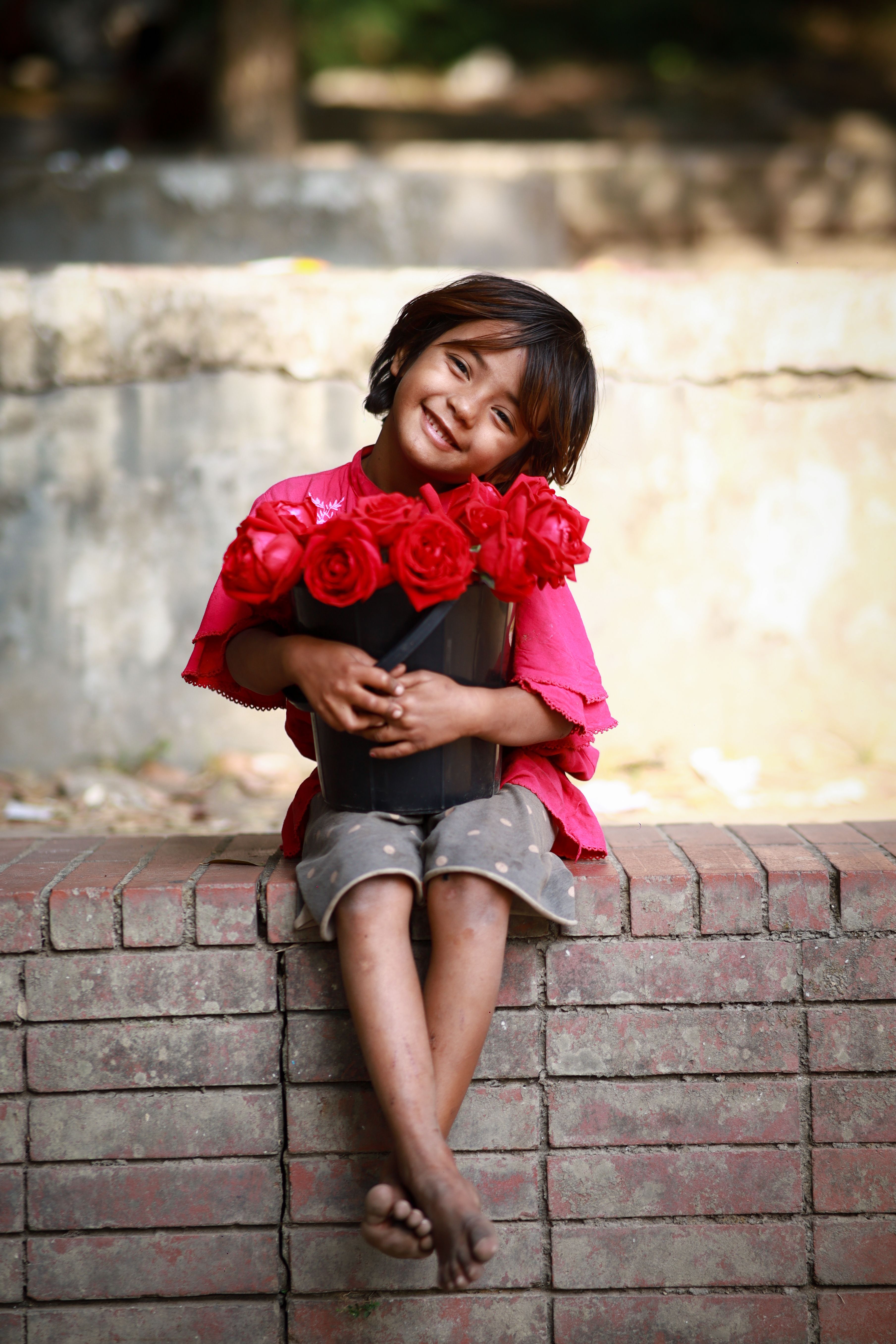 Little Girl Holding Bouquet of Red Roses · Free Stock Photo