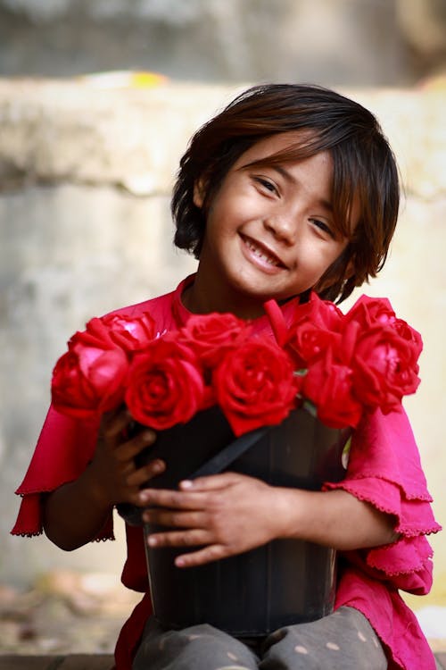 A little girl holding a bunch of roses