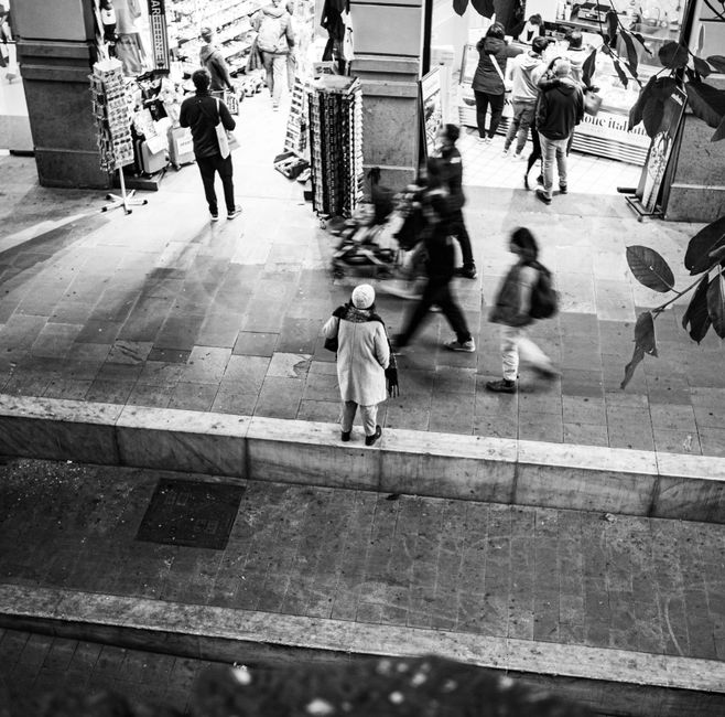 Foto en blanco y negro que captura peatones en una bulliciosa calle de Barcelona.