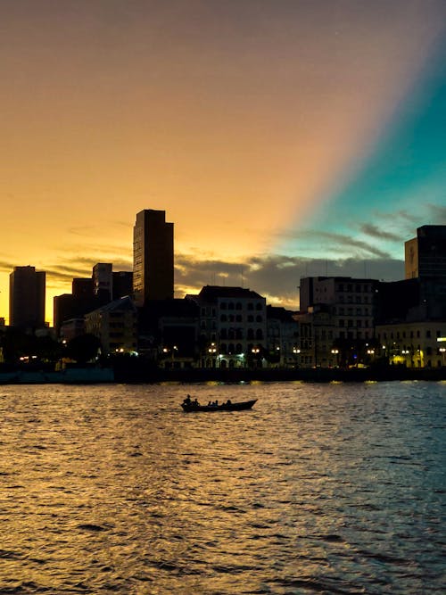 Free A boat is in the water near a city skyline Stock Photo