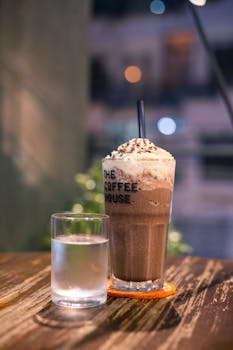 A delicious iced chocolate drink with cream on a wooden table in Ho Chi Minh City cafe.