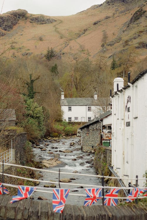 A river with flags hanging from it and a house