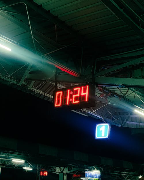 Free A clock on a train platform at night Stock Photo