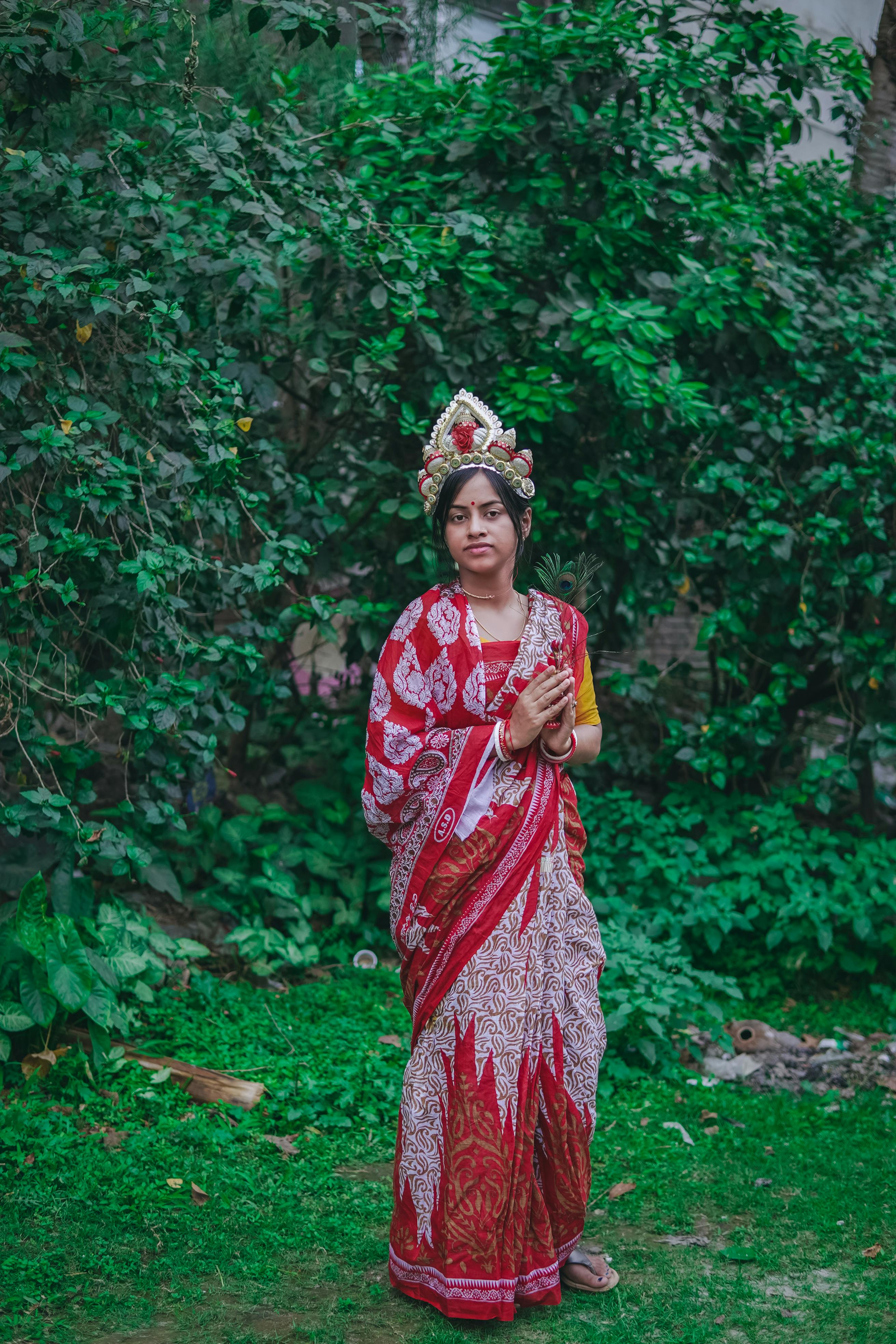 a woman in a traditional sari standing in a garden