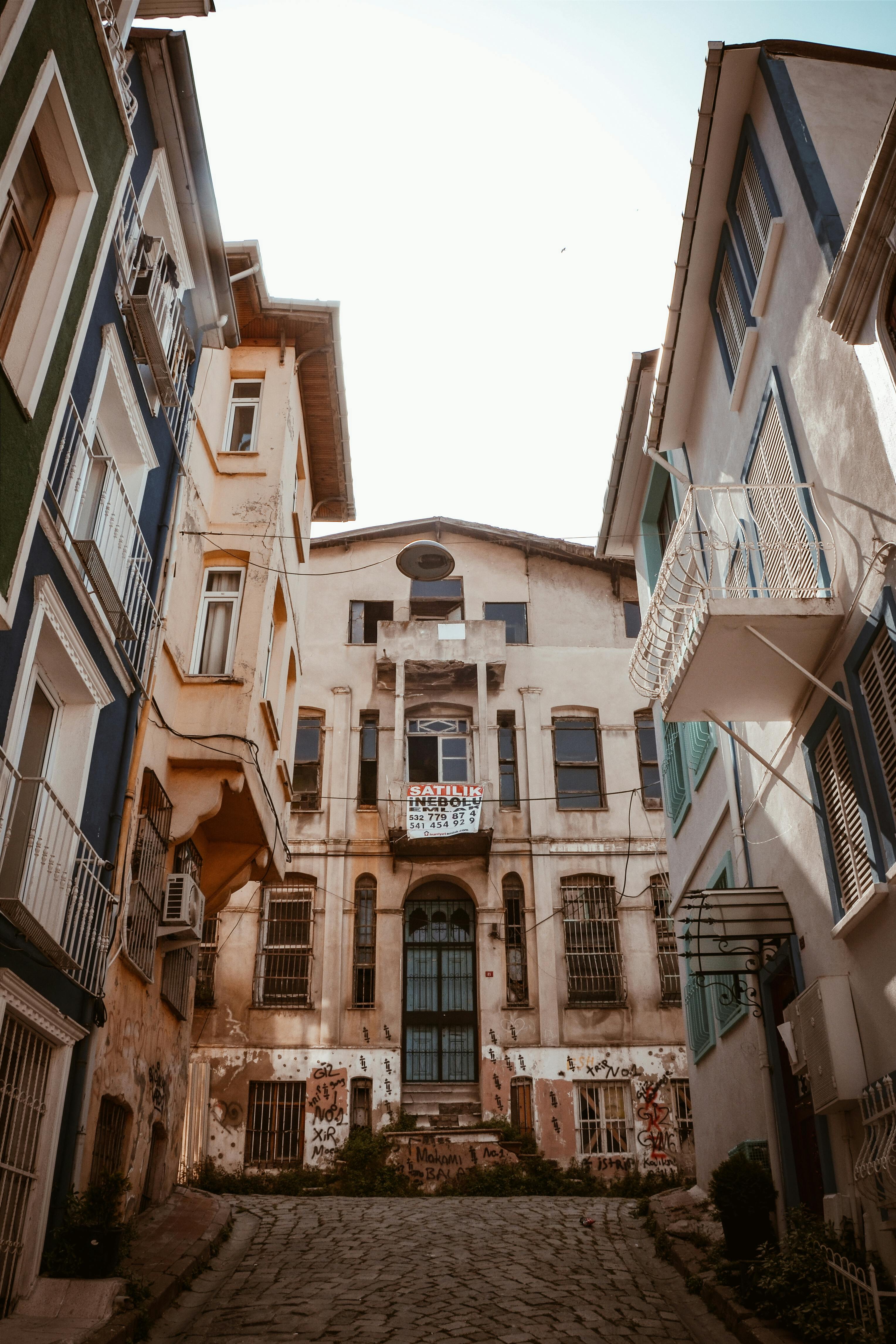 阳光明媚的日子里，沿着一条狭窄的鹅卵石街道漫步，两旁排列着历史建筑，外墙色彩缤纷