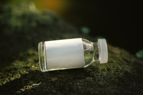 Free A small bottle of liquid sitting on a rock Stock Photo