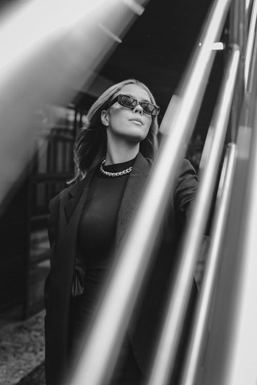 A woman in sunglasses standing on a metal railing
