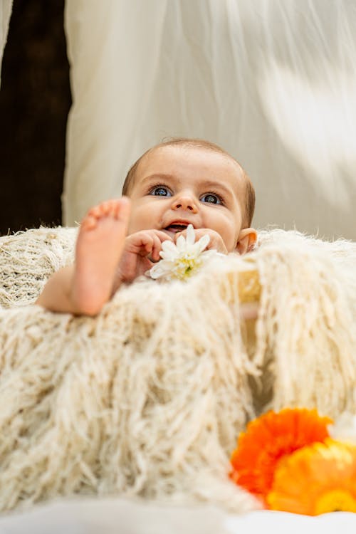 Free A baby is laying on a blanket with flowers Stock Photo