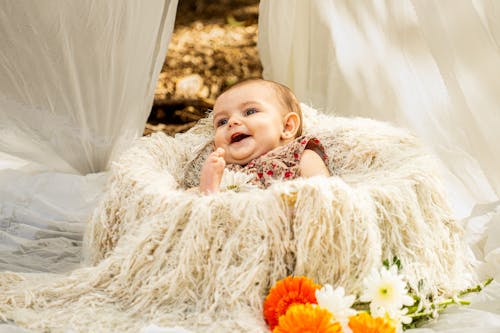 Free A baby is sitting in a blanket with flowers Stock Photo