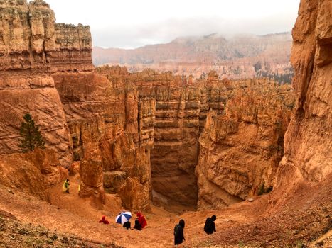 Explore the stunning rock formations and trails of Bryce Canyon, Utah with hikers in vibrant clothing.