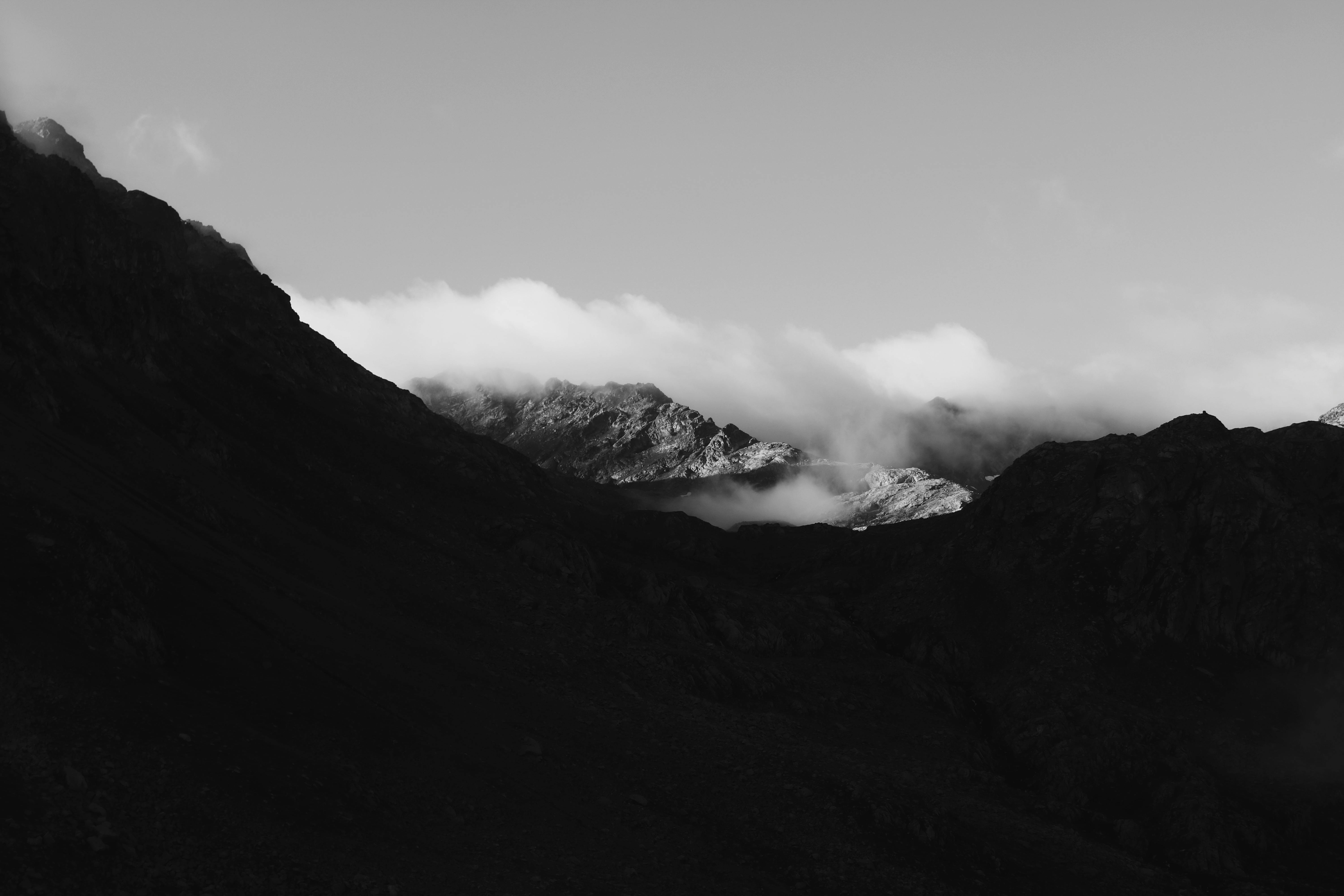 Dramatic black and white mountain landscape in Rize, Türkiye, showcasing clouds and rugged peaks.