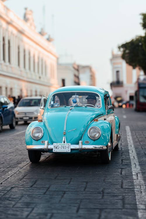 Turquoise Volkswagen Garbus Against Urban Background