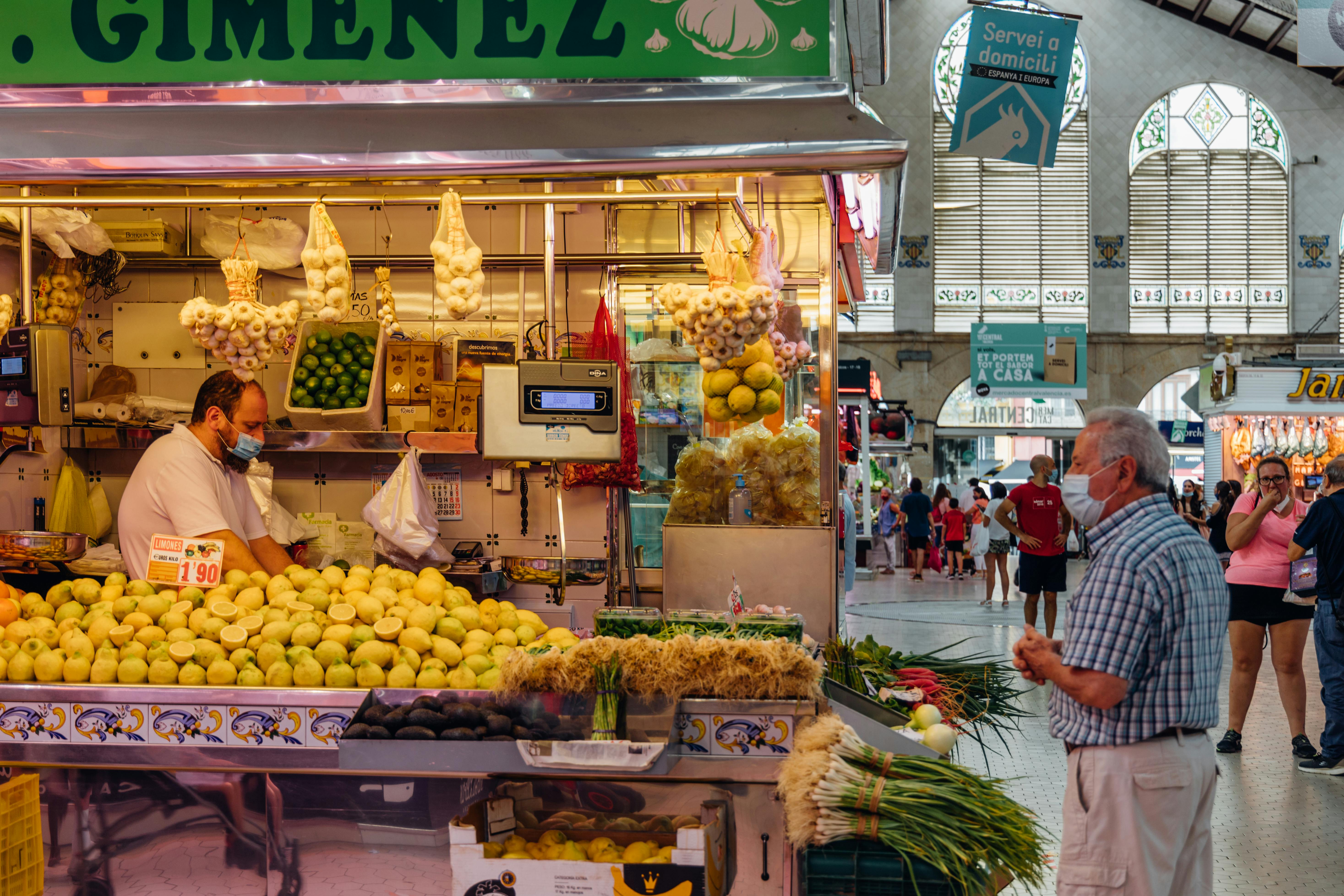 a man standing in front of a fruit stand