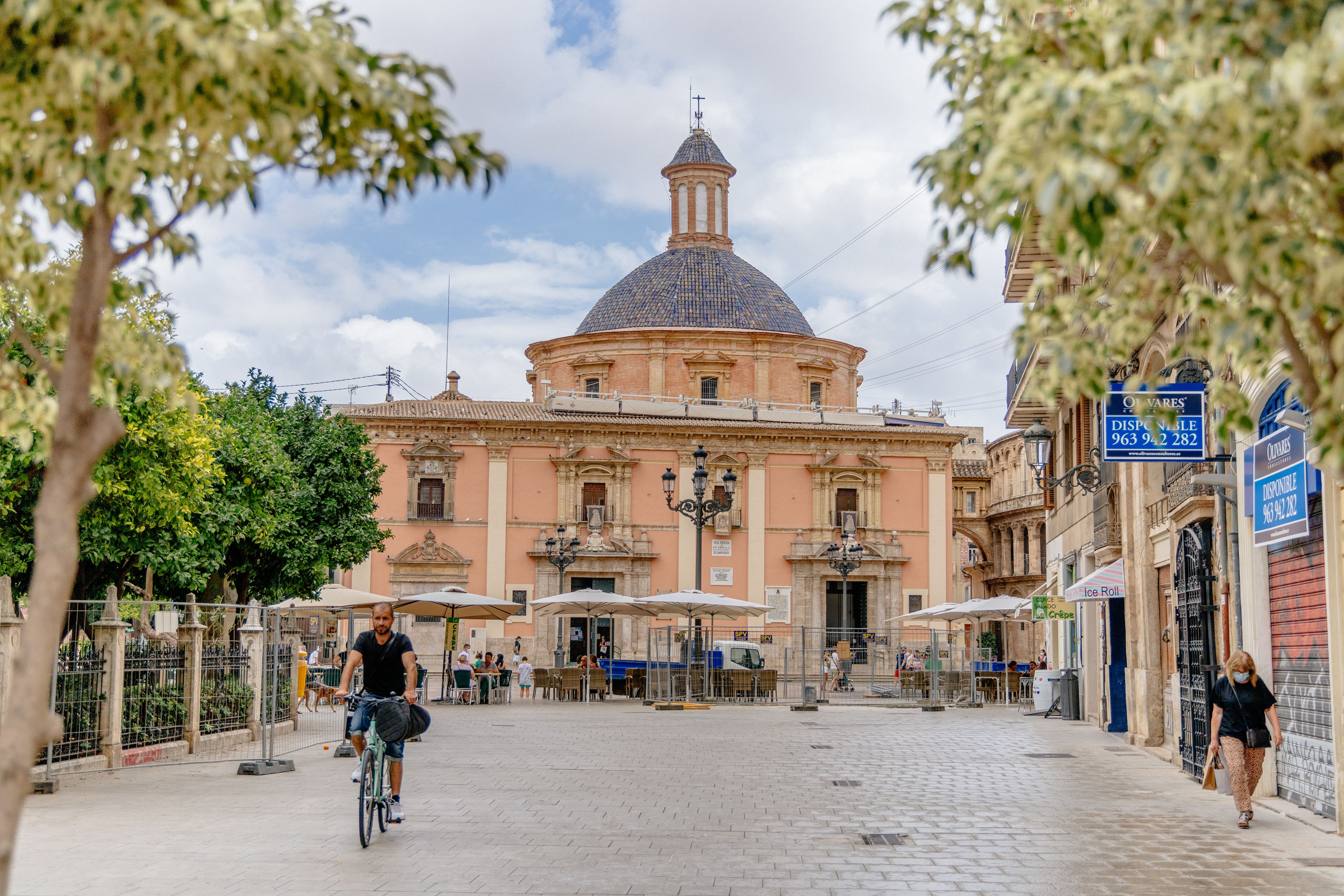 Scenic view of a cyclist on a city street near Valencia Cathedral, Spain.