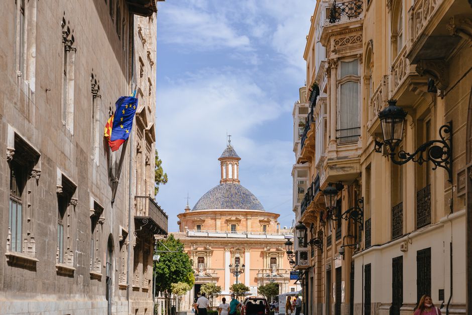 Descubre la belleza arquitectónica de las históricas calles de Valencia, con monumentos icónicos bajo un brillante cielo azul.