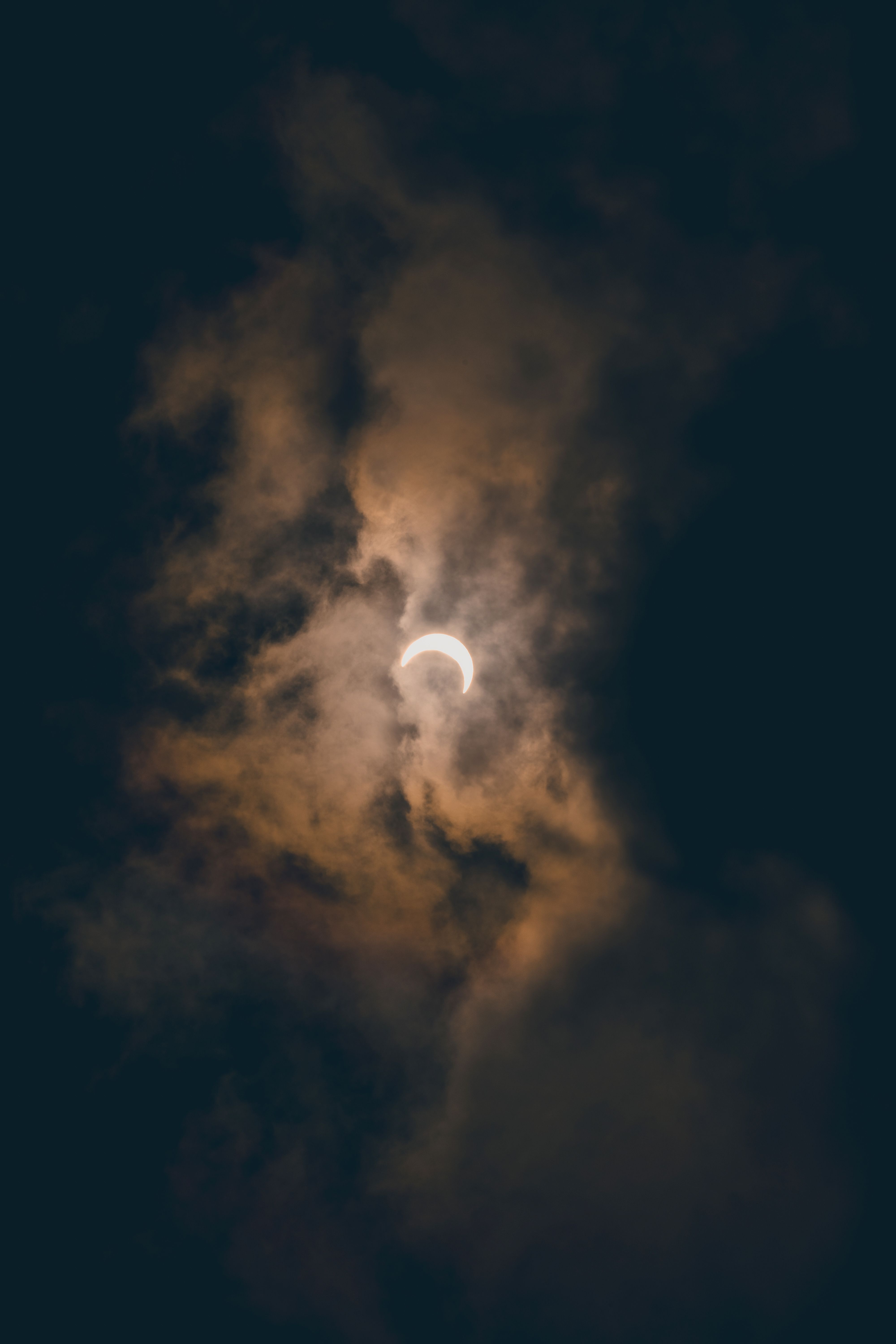 A captivating view of a solar eclipse surrounded by dramatic, moody clouds in Akumal, México.