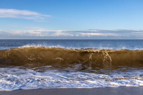 Free Capturing a stunning wave at Sylt beach under a clear blue sky. Perfect for nature and travel themes. Stock Photo