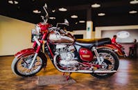 一辆经典的红色摩托车在带有环境照明的室内展厅中展出