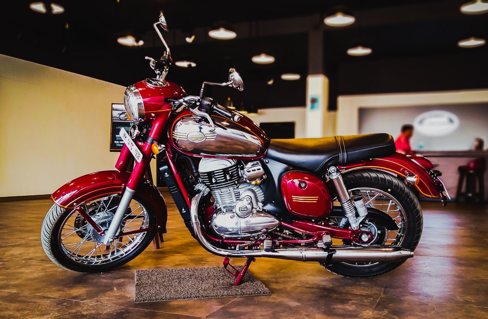Moto classique rouge exposée dans un showroom sous un éclairage tamisé